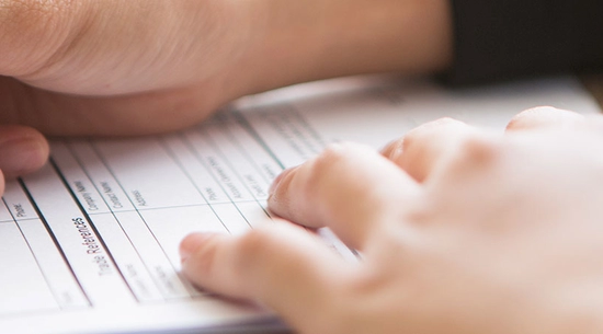 Person writing on a form
