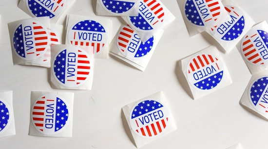 "I Voted" stickers scattered on a white desk