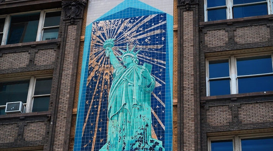 Photo of a mural on the side of a building; it is the statue of liberty in the mural